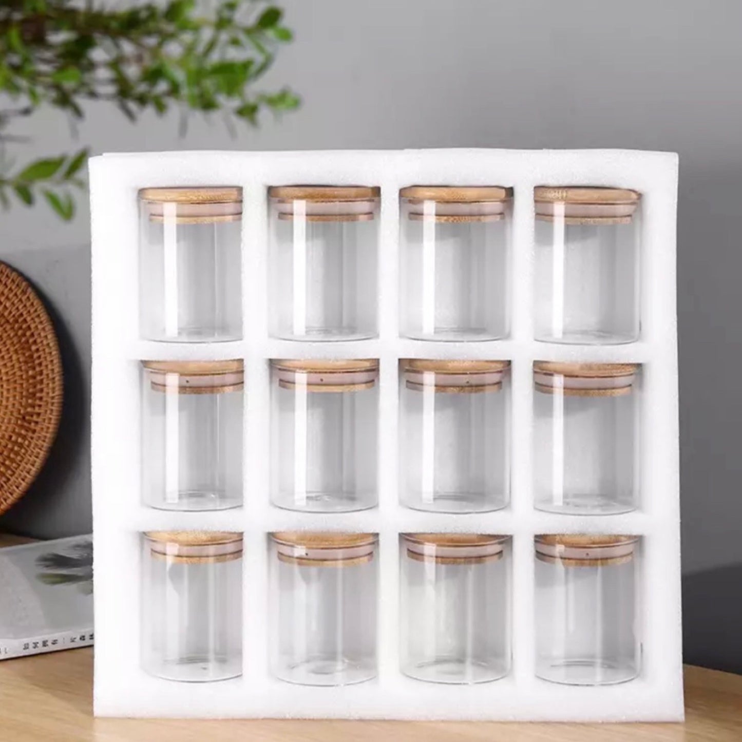 Ein Set aus zwölf leeren Gewürzgläsern mit Bambusdeckeln, präsentiert in einer weißen Schaumstoffhalterung. Die Gläser sind in einer 3x4-Anordnung aufgestellt und bieten eine schlichte, aber elegante Möglichkeit, Gewürze sichtbar und griffbereit zu halten.