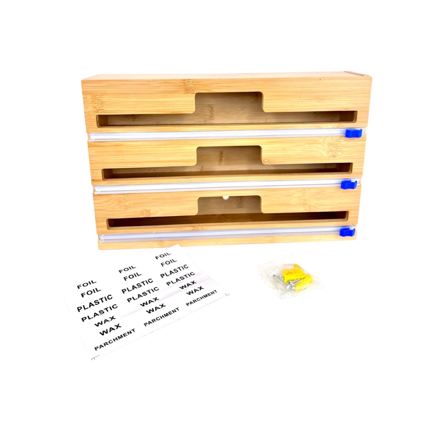 Ein dreistufiger Folienspender aus Holz, neben dem Beschriftungen für die verschiedenen Folientypen liegen: Alufolie, Plastikfolie und Wachspapier. In der Nähe befindet sich eine kleine, in Plastik verpackte teile an der Wand zu befestigen. Die strukturierte Holzoberfläche ist gut sichtbar, und die blauen Endkappen an den silbernen Schneideleisten stechen deutlich hervor, was auf eine organisierte und benutzerfreundliche Küchenhilfe hinweist.