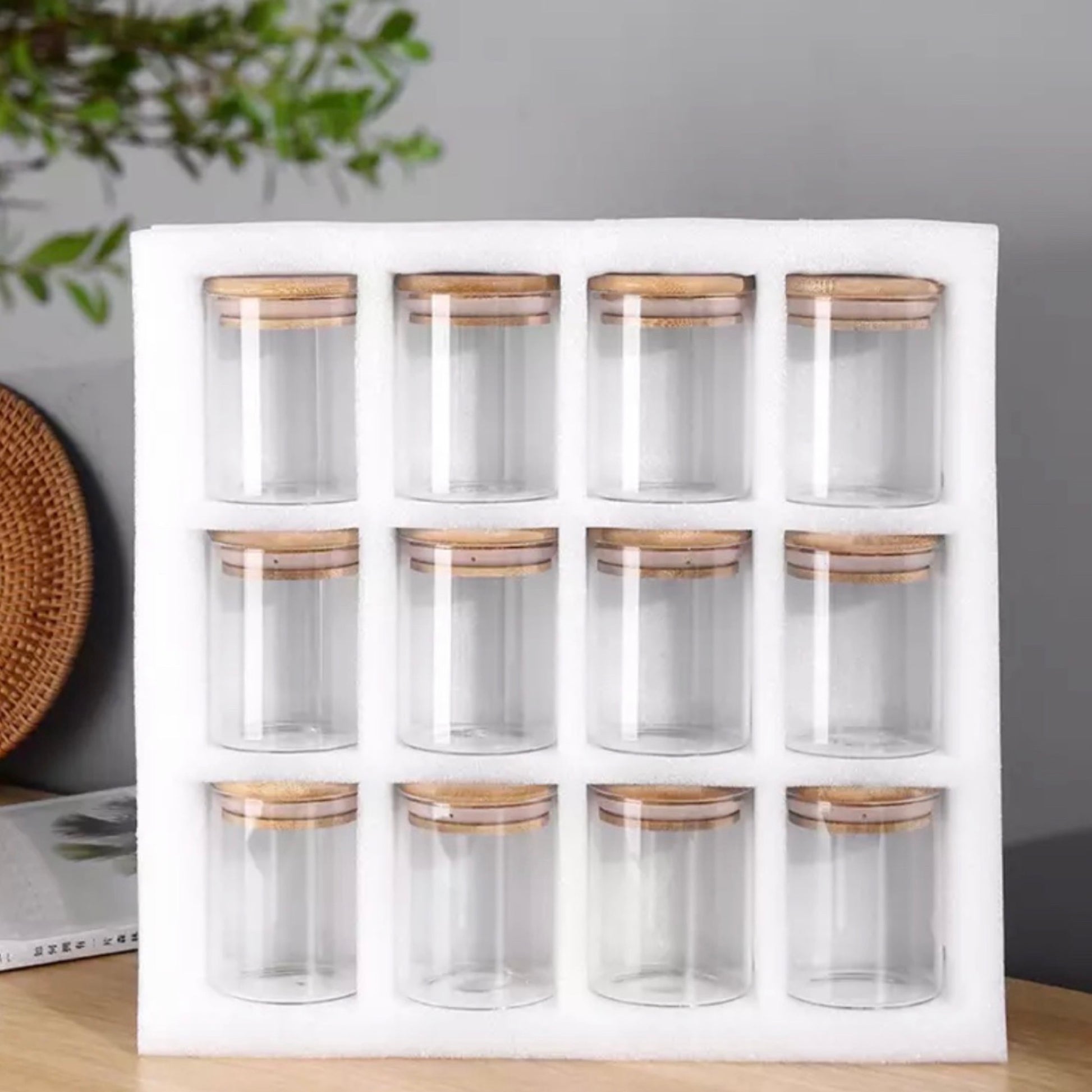 Ein Set aus zwölf leeren Gewürzgläsern mit Bambusdeckeln, präsentiert in einer weißen Schaumstoffhalterung. Die Gläser sind in einer 3x4-Anordnung aufgestellt und bieten eine schlichte, aber elegante Möglichkeit, Gewürze sichtbar und griffbereit zu halten.