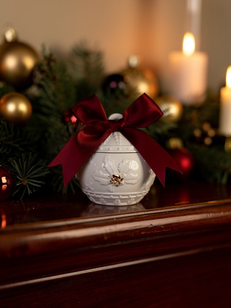 Handgefertigter Kerzenhalter in Weihnachtskugel-Form mit roter Schleife, dekoriert vor Tannenzweigen und Kerzen – stilvolle Weihnachtsdeko aus der Schweiz.Geschenkidee für Weihnachten