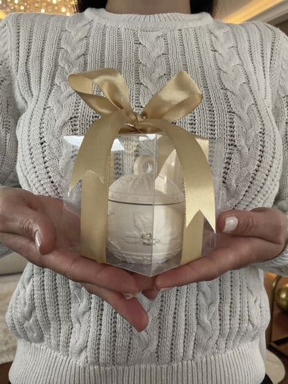 Handgefertigter Kerzenhalter in Weihnachtskugel-Form in transparenter Geschenkbox mit goldener Schleife, in Händen präsentiert – ideales Weihnachtsgeschenk aus der Schweiz.