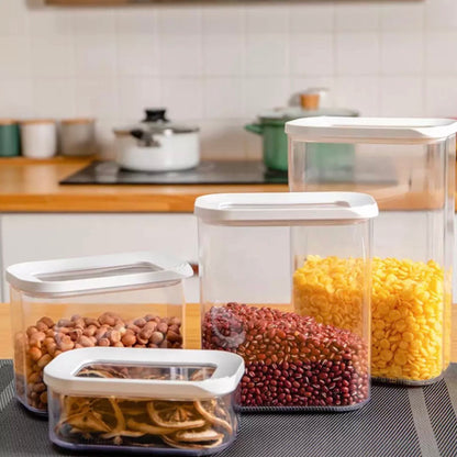 Set aus durchsichtigen Vorratsdosen in verschiedenen Größen auf einer Küchenarbeitsplatte, gefüllt mit Hülsenfrüchten und getrockneten Zitronenscheiben. Diese Behälter bieten eine klare Sicht auf ihren Inhalt und sind ideal zur übersichtlichen Aufbewahrung in der Küche