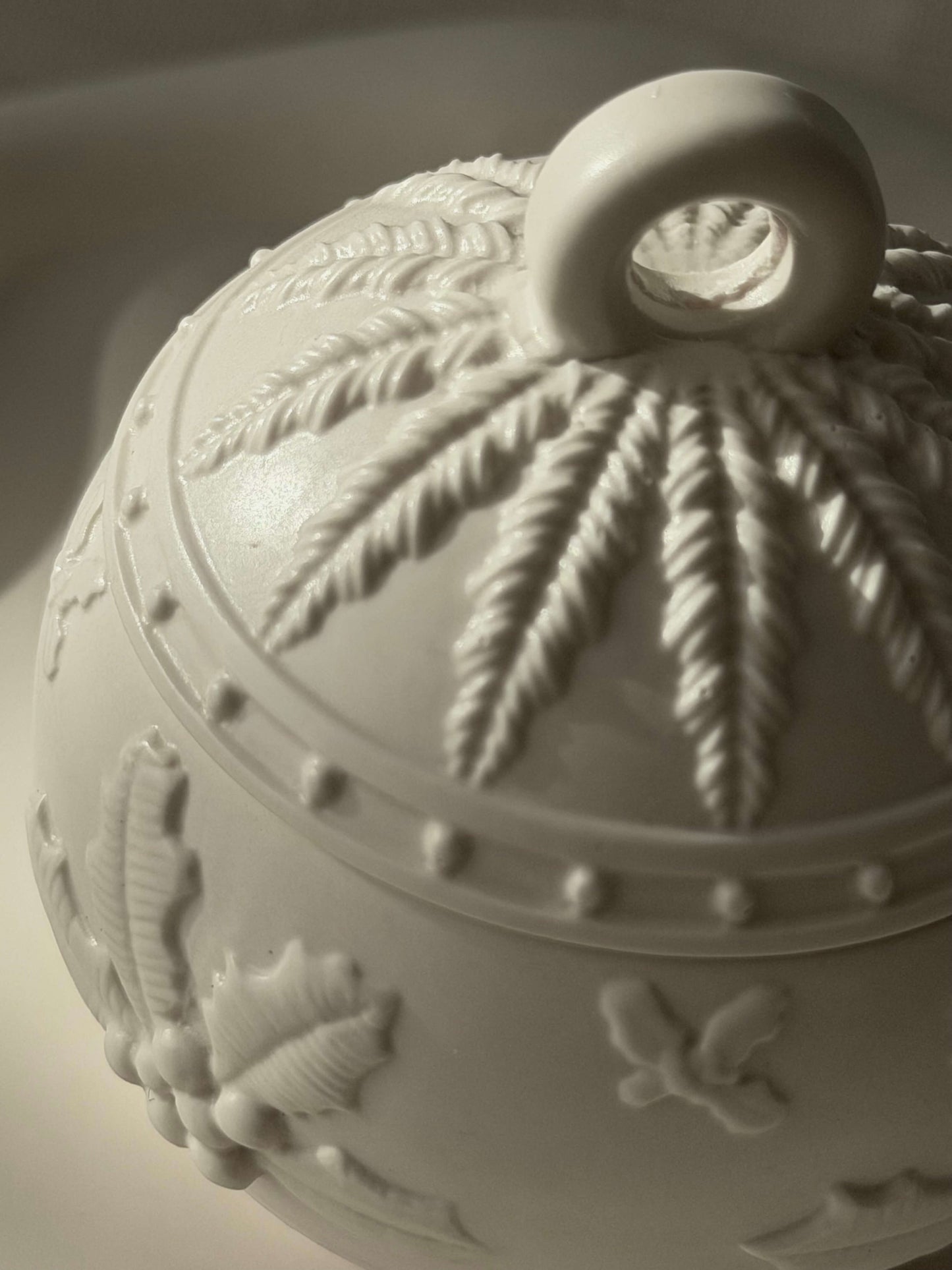 Nahaufnahme der handgefertigten Weihnachtskugel von oben, mit detailliertem Winterrelief und natürlicher Lichtstimmung