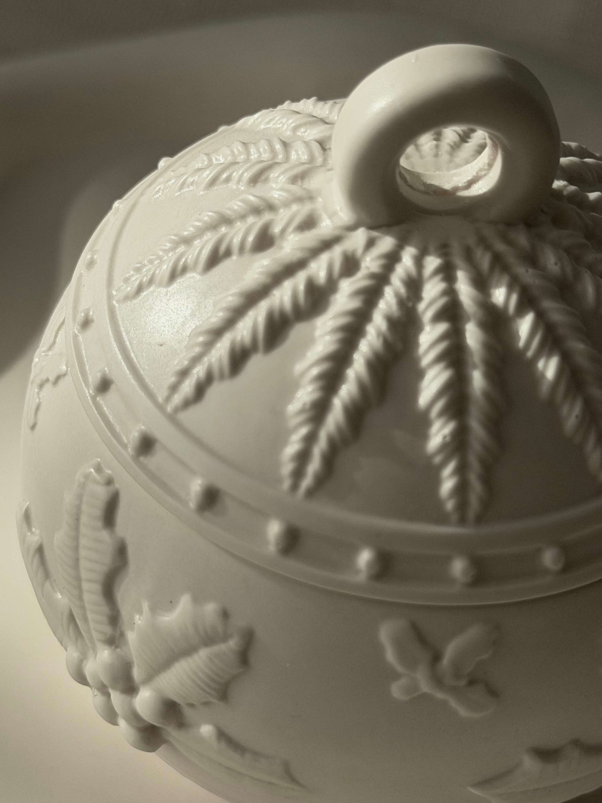 Nahaufnahme der handgefertigten Weihnachtskugel von oben, mit detailliertem Winterrelief und natürlicher Lichtstimmung