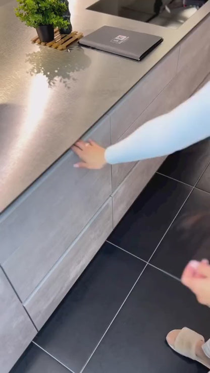 Das Video zeigt die praktische Nutzung von Küchenorganizern in einer Schublade. Zuerst wird ein Messer-Organizer mit verschiedenen großen und kleinen Messern befüllt. Anschließend werden zwei Besteck-Organizer präsentiert: einer wird mit silbernem Besteck, der andere mit goldenem Besteck bestückt. Zum Schluss wird ein Gewürz-Organizer mit runden Gewürzgläsern, die mit verschiedenen Gewürzen gefüllt sind, aufgefüllt, was für eine geordnete und ansprechende Küchenumgebung sorgt.